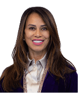 Professional woman with long dark hair smiling, wearing a light shirt and purple blazer.